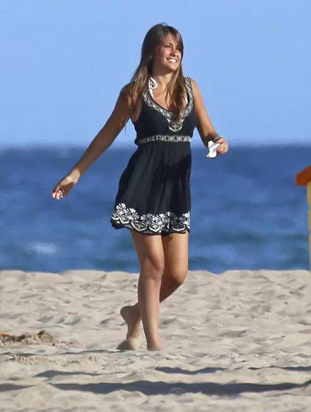 身穿一件黑色背心裙在海滩,虽然阳光热辣,但是安东内拉的外形也是很