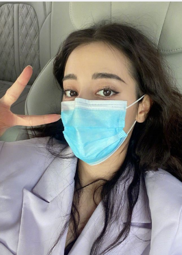 迪丽热巴身穿休闲西装,长发凌乱的披在加上,戴着口罩,但是仍挡不住她