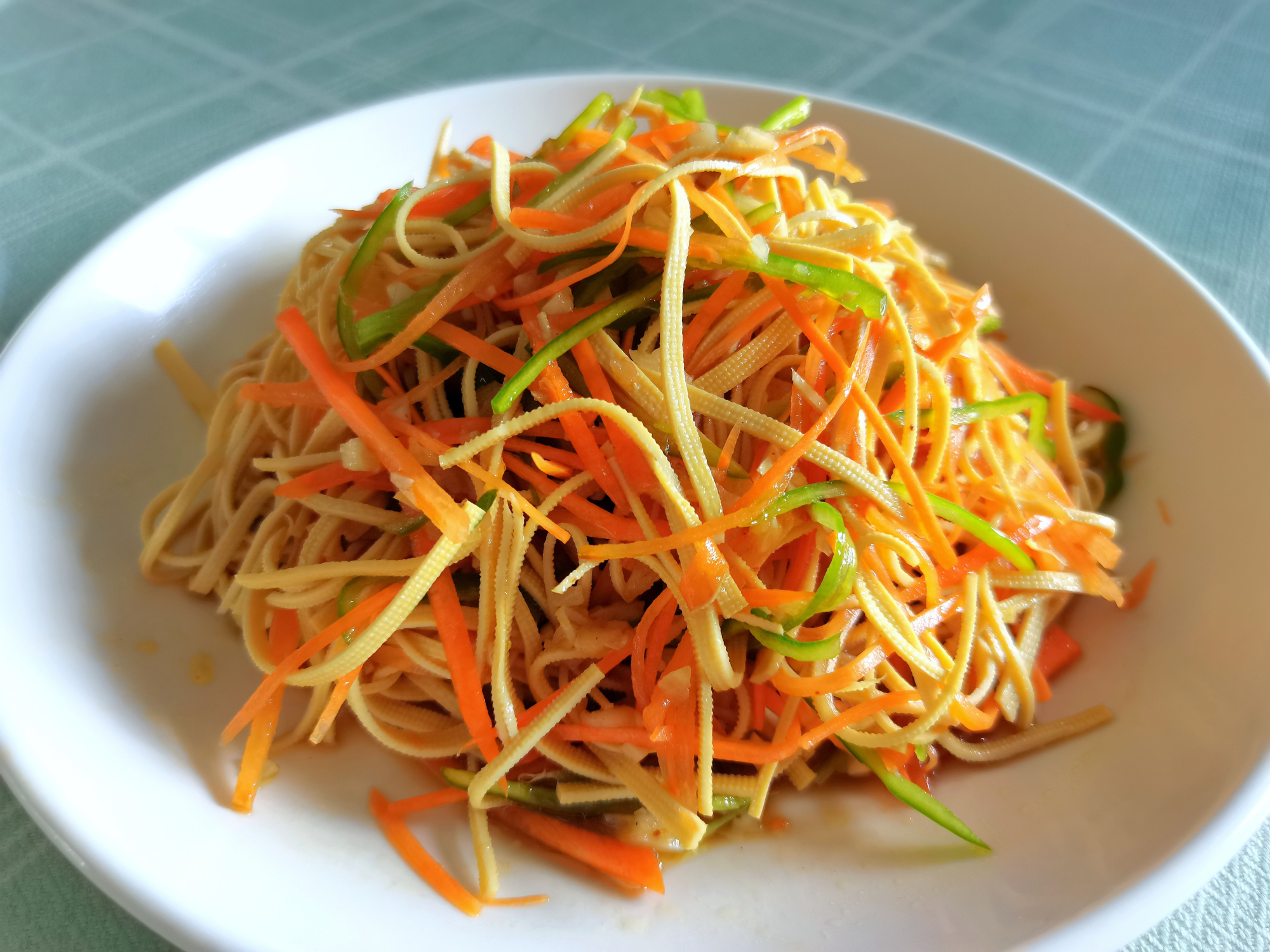 花生米及调料汁一起浇到蔬菜上,搅拌均匀,好吃的花生米拌三丝就做好了