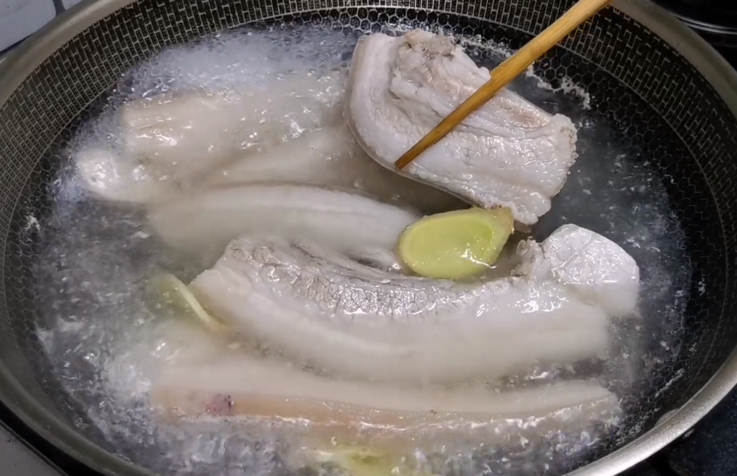 2,切好的猪肉冷水下锅,加入姜片,料酒去腥,大火烧开撇去浮沫,再煮5