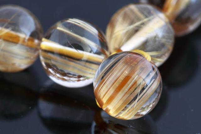 在玻璃或者人造水晶中,植入染色的特殊纤维,就可以模仿成天然发晶的