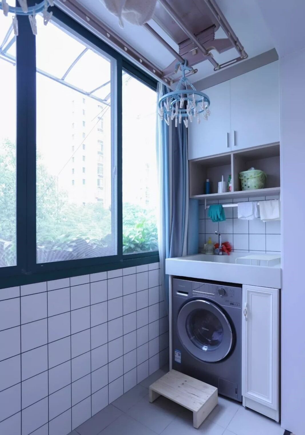 阳台一侧是内嵌式洗衣机,旁边还装了一个小收纳柜,洗衣液柔顺剂都放