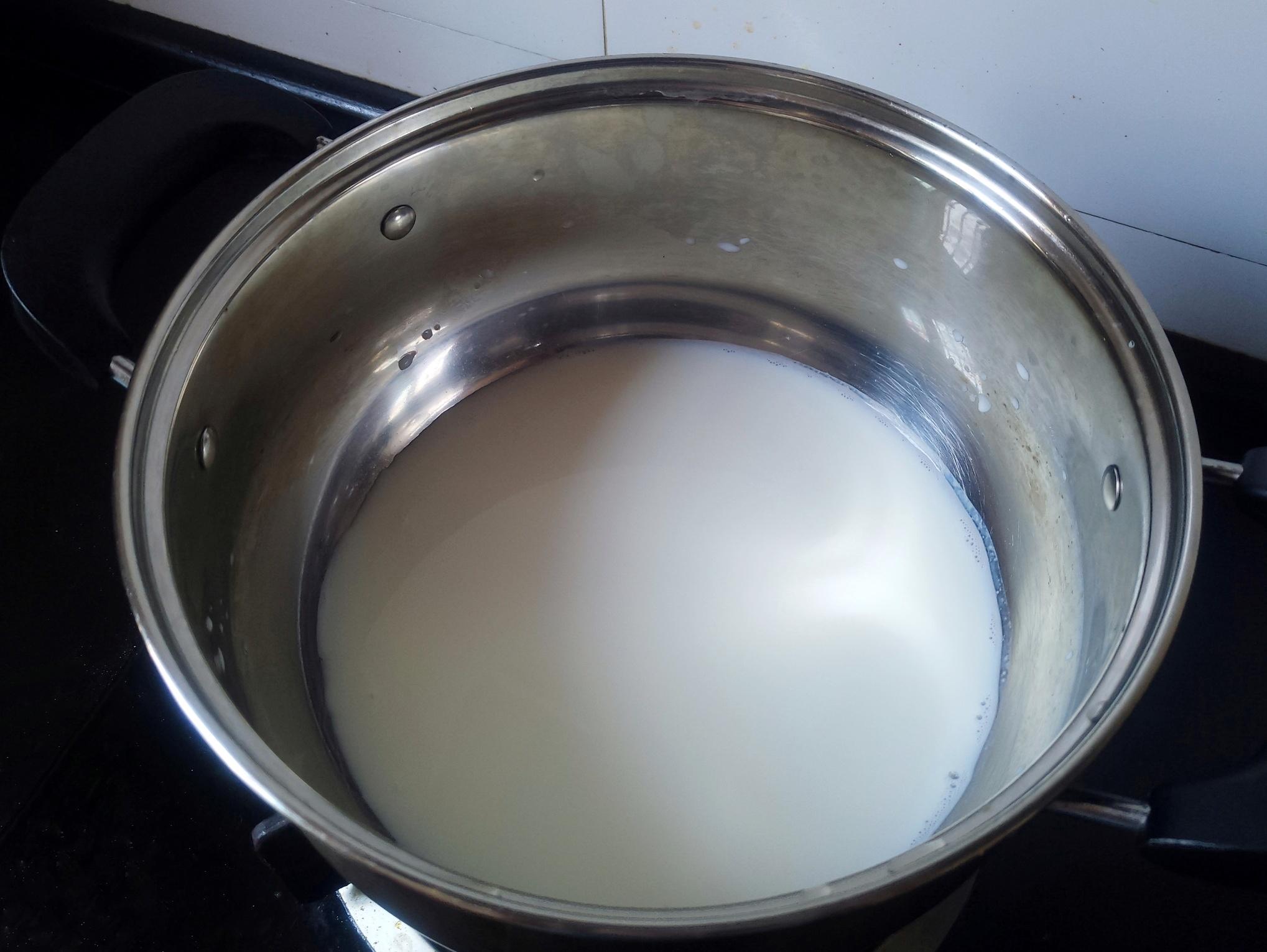 3,接着开始加热牛奶,将200克的纯牛奶倒入锅中,用中小火慢慢加热,加热