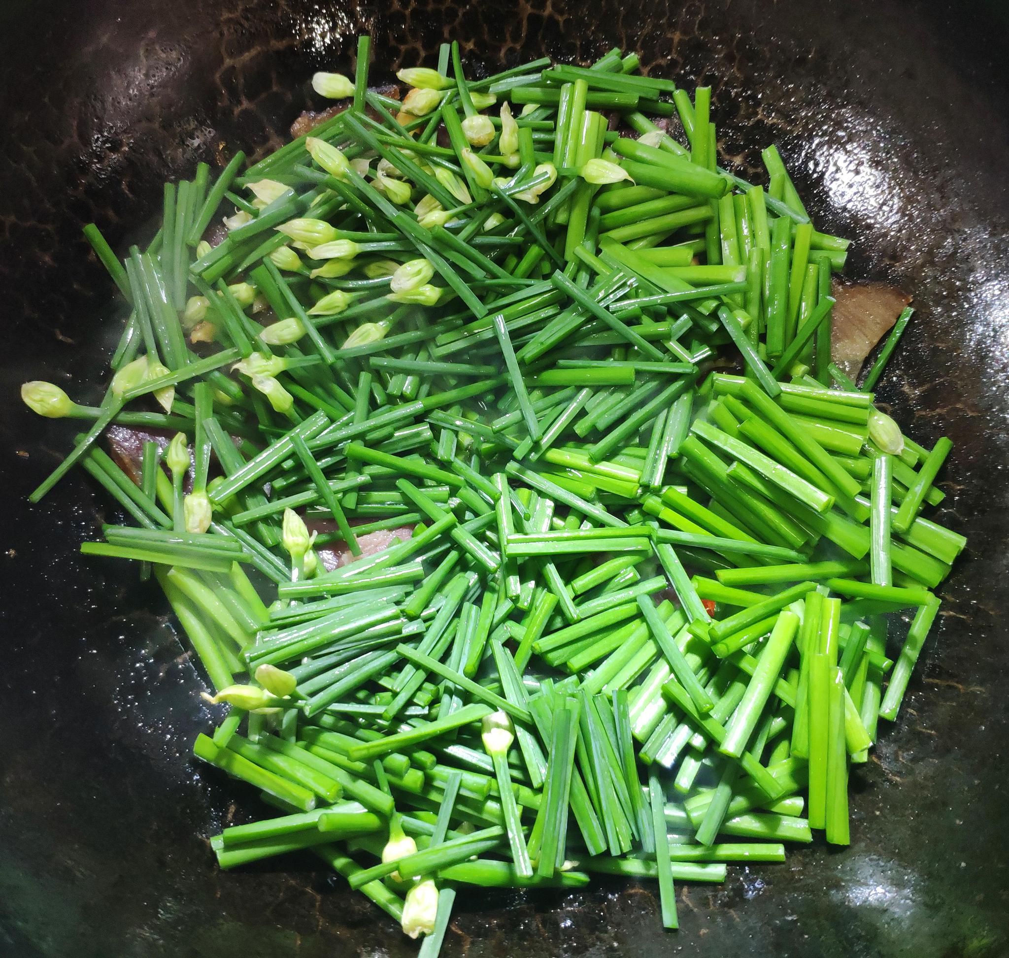 5,快速煸炒至韭菜心变色,加入少量酱油,盐调味:6,加入韭菜心后煸炒