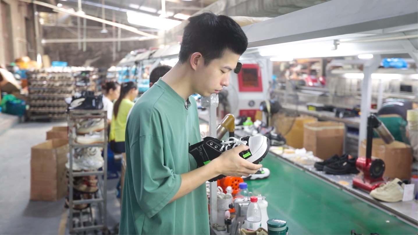 欧豪在生产线检查鞋子质量