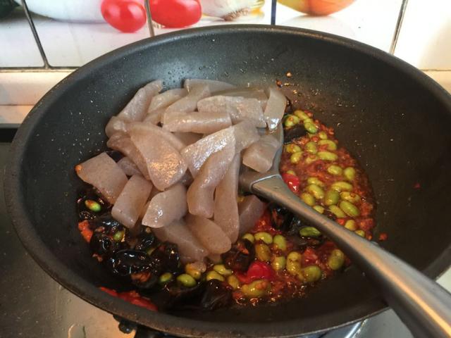 8,魔芋条翻炒均匀后,往锅中倒入一碗水,再加入半个浓汤宝,大火转小火