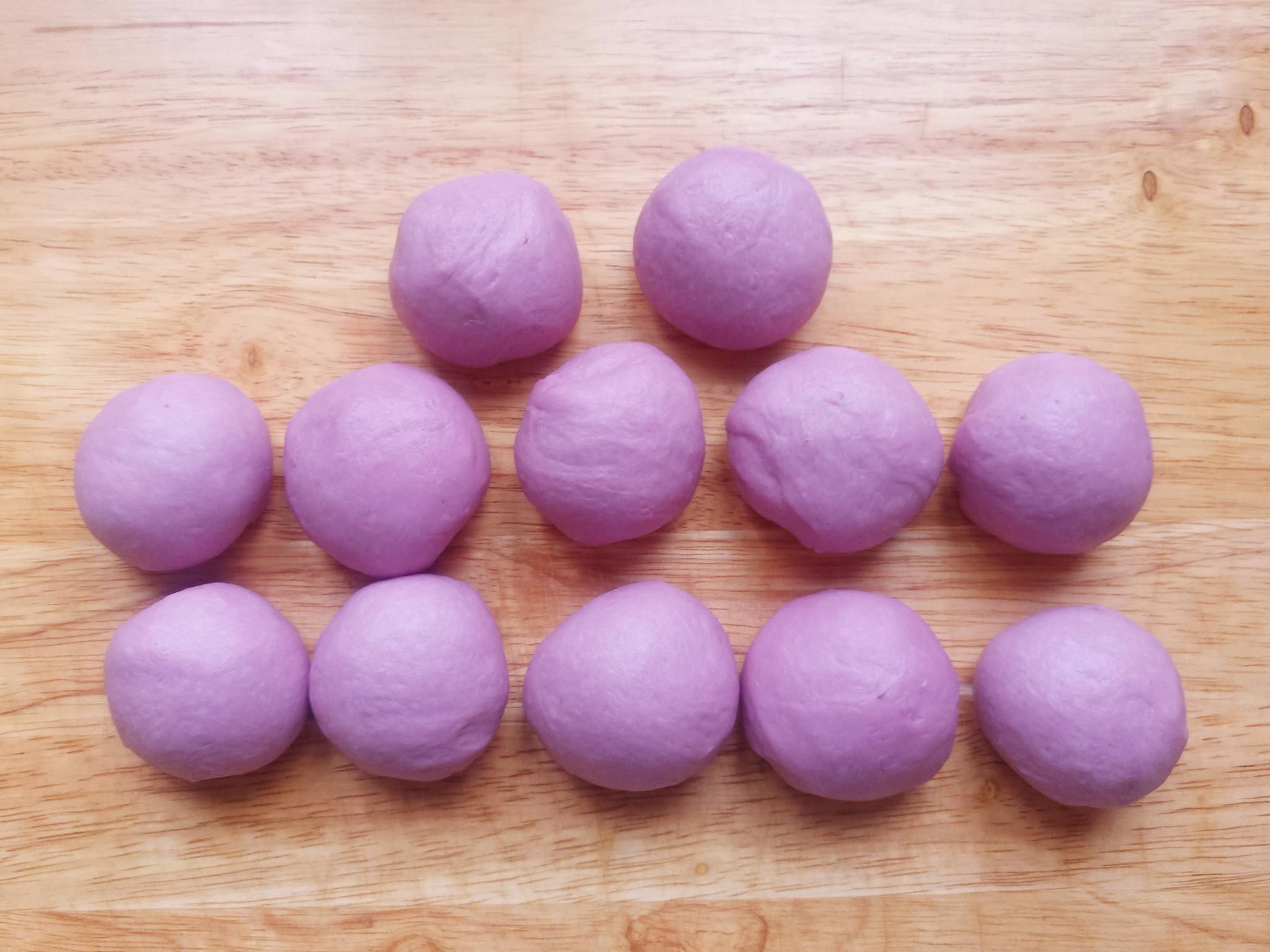 7,10分钟后,将紫薯面团均匀的分成12等份,挨个搓圆后,盖上保鲜膜防止