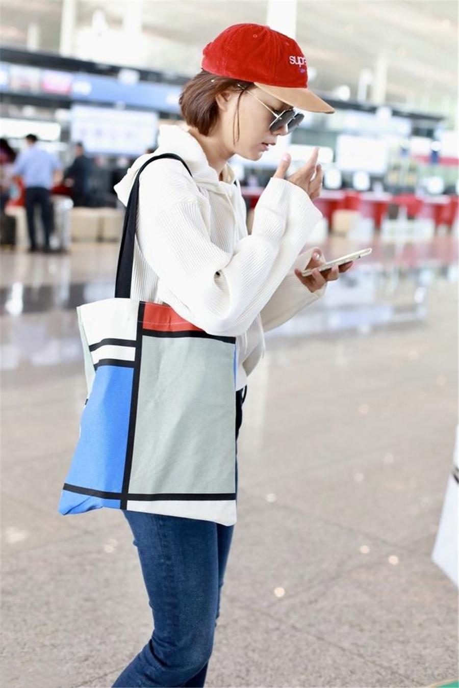 王珞丹戴小红帽走机场,卫衣搭牛仔裤休闲减龄,短发造型飒爽利落