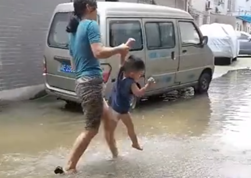 萌娃站在水坑里不知所措,亲妈单手拎娃引争议,网友:不怕脱臼?