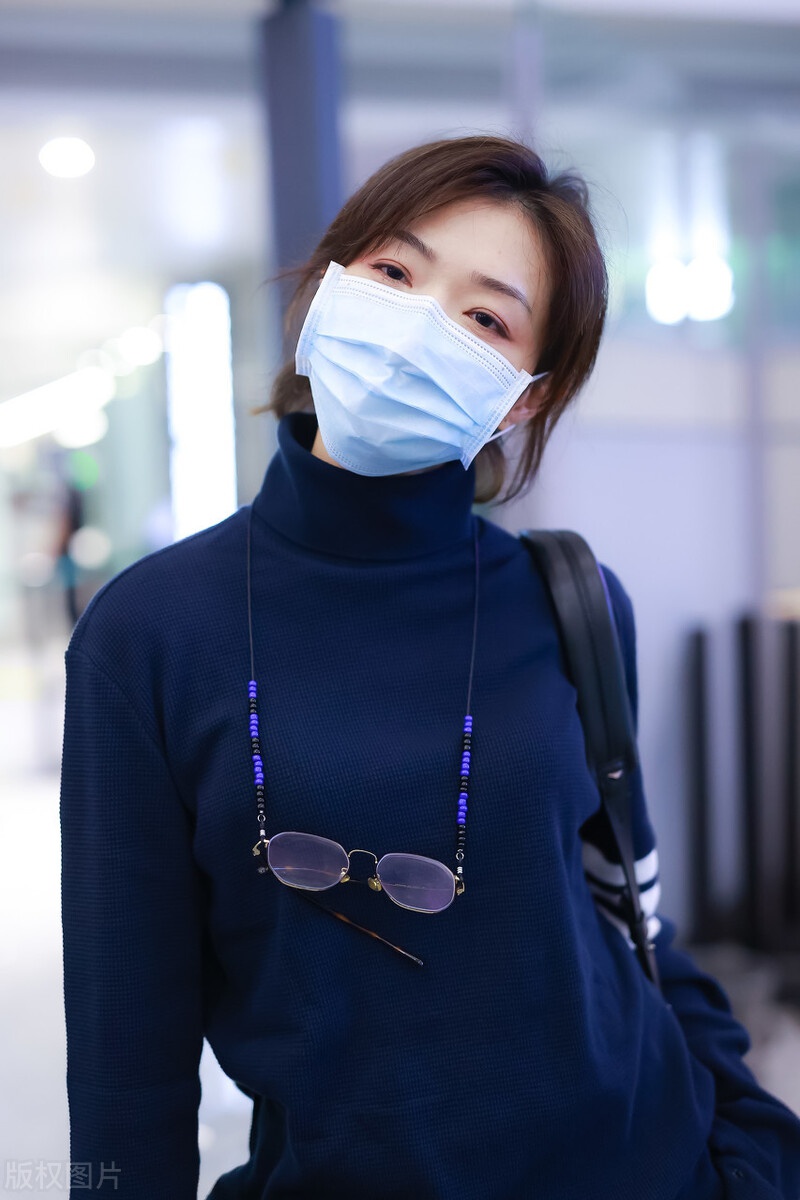 万茜穿蓝色高领针织衫现身机场,俊俏可爱玩起了行李箱