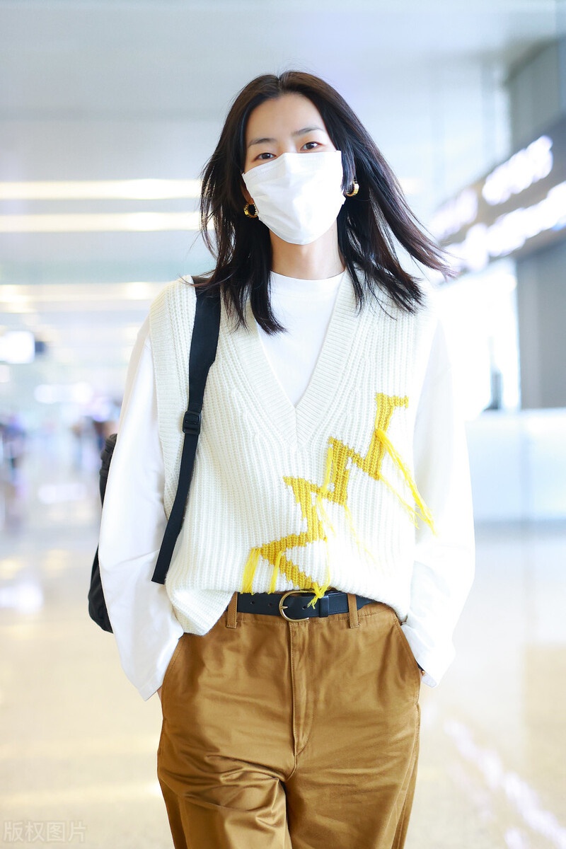 刘雯穿白色针织衫,搭配卡其色裤子,挥手打招呼尽显个人气质