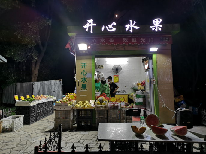 搬到城管安排的亭棚后，王兆阳给水果店取名为“开心水果”。新京报记者 周小琪 摄