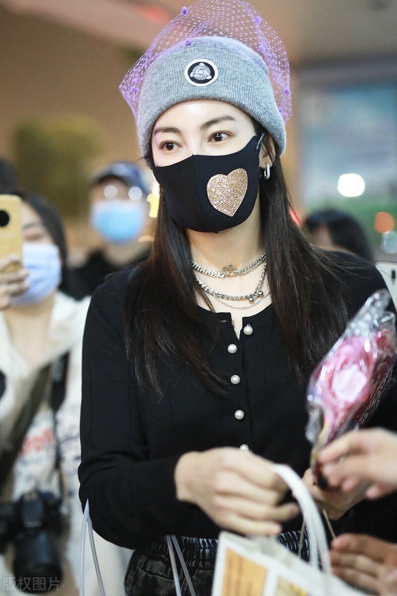 张雨绮化身时尚达人戴粉色渔网帽现身机场,金色爱心口罩更是夺目