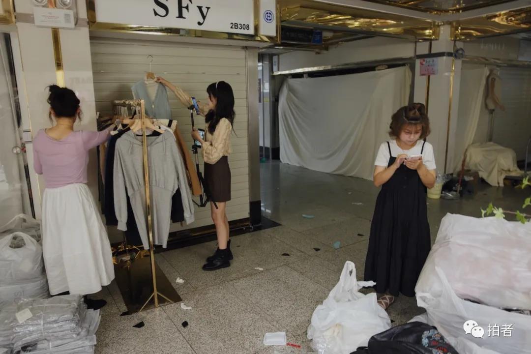△ 9月27日，广州万佳服装批发市场，阿燕（右一）用手机统计货物数量。