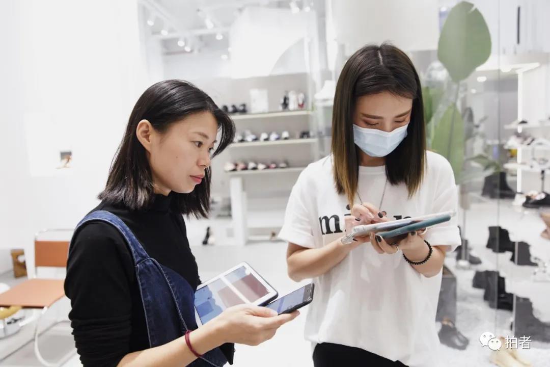 △9月25日，广州ARAapM服装批发市场里，卜桐在一家档口前报单拿货。