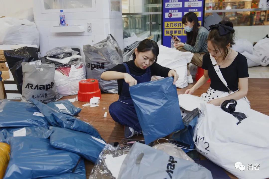 △ 9月25日，广州ARAapM服装批发市场里，卜桐打包封装货物，当天她卖出了10件货。