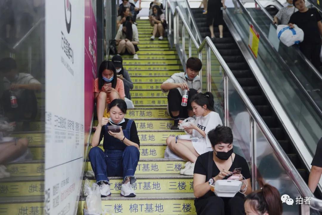 △9月25日中午，广州万佳服装批发市场，卜桐在市场的楼梯处快速解决午饭。