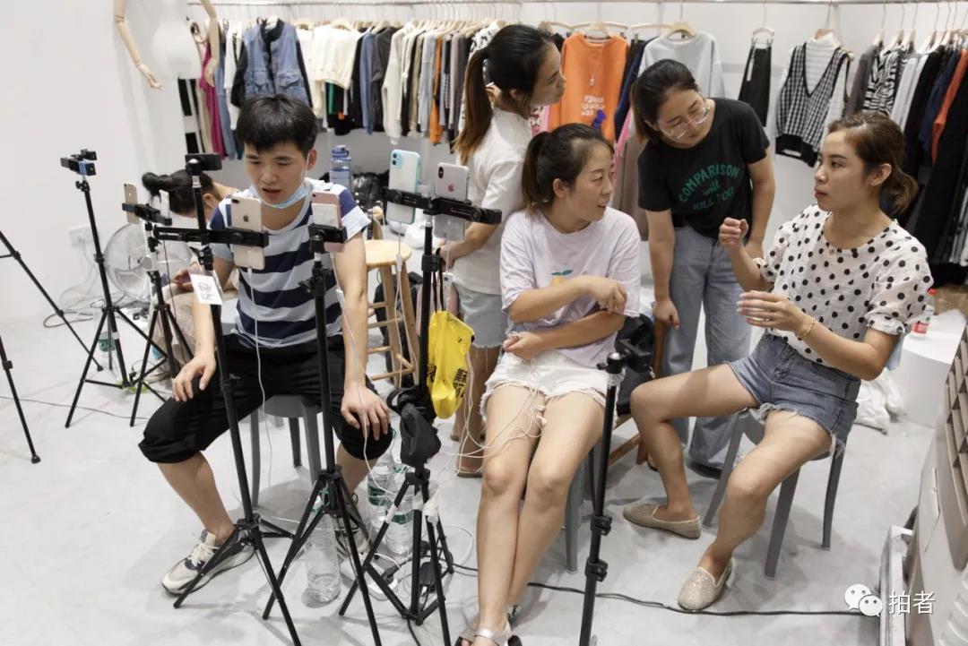 △9月26日，广州万佳服装批发市场，主播们在空闲时间讨论直播经验。