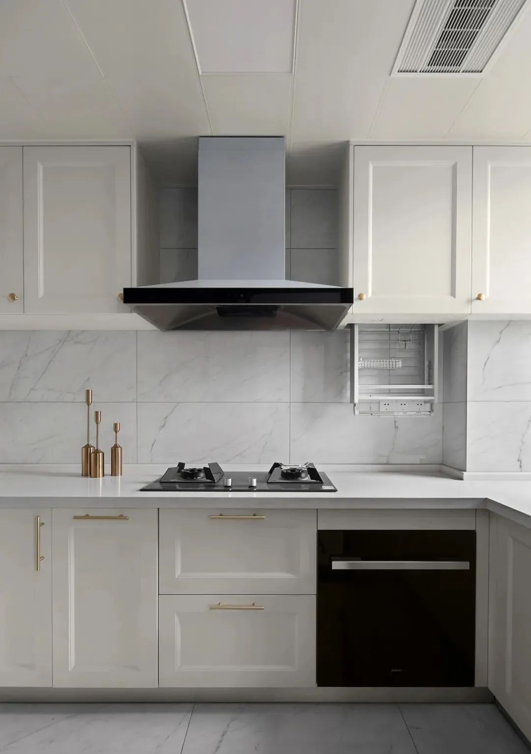 厨房,白色石纹砖墙地一体,浅色调橱柜点缀金色把手凸显质感,吊柜