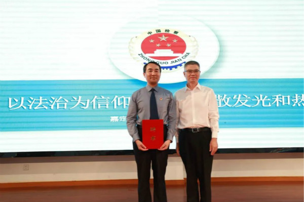 图说:嘉定区第二中学党总支书记,校长宋保平(右)为嘉定区检察院检察长