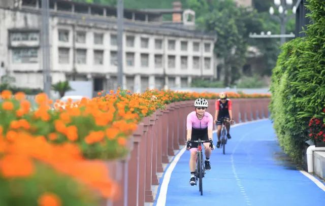 ▲7月23日，市民在重庆市江北区北滨路漫行步道的自行车道上骑行。新华社图。