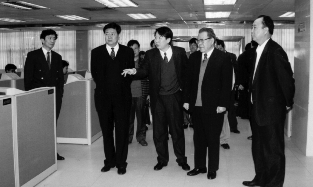 图7.7 1996年11月，中共中央组织部部长张全景（右二）视察深圳证券交易所。深圳市委书记厉有为（右一）、李子彬（左二）和副市长武捷思（左一）陪同，庄心一（中）汇报情况