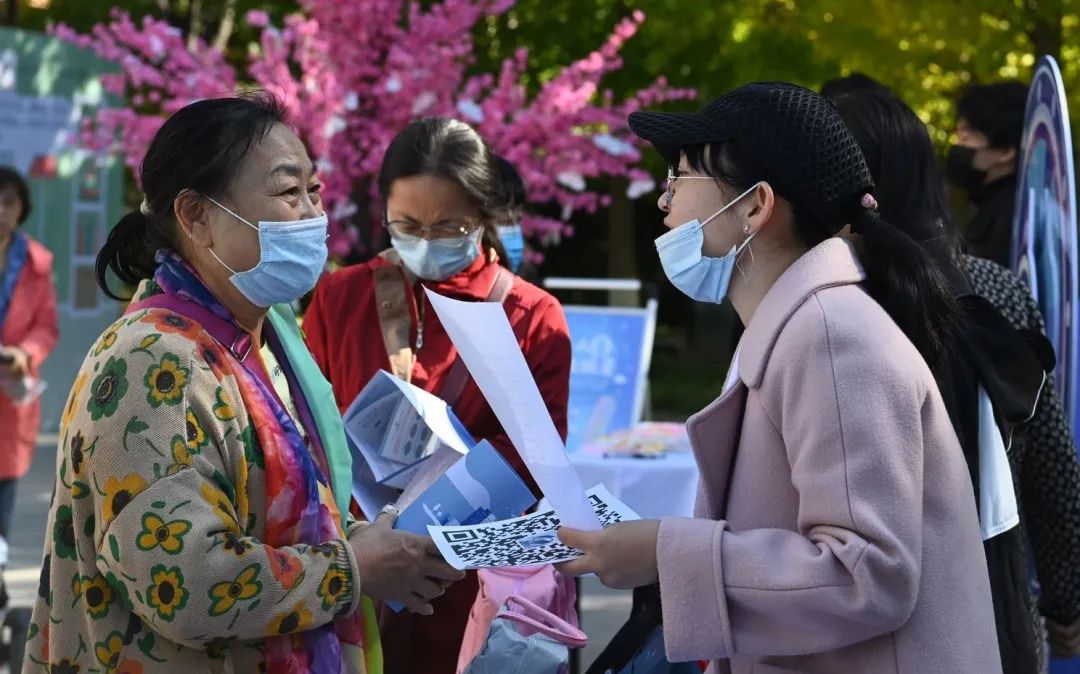 ▲七人普社区行活动现场，工作人员向居民宣传人口普查。摄影/新京报记者 陶冉