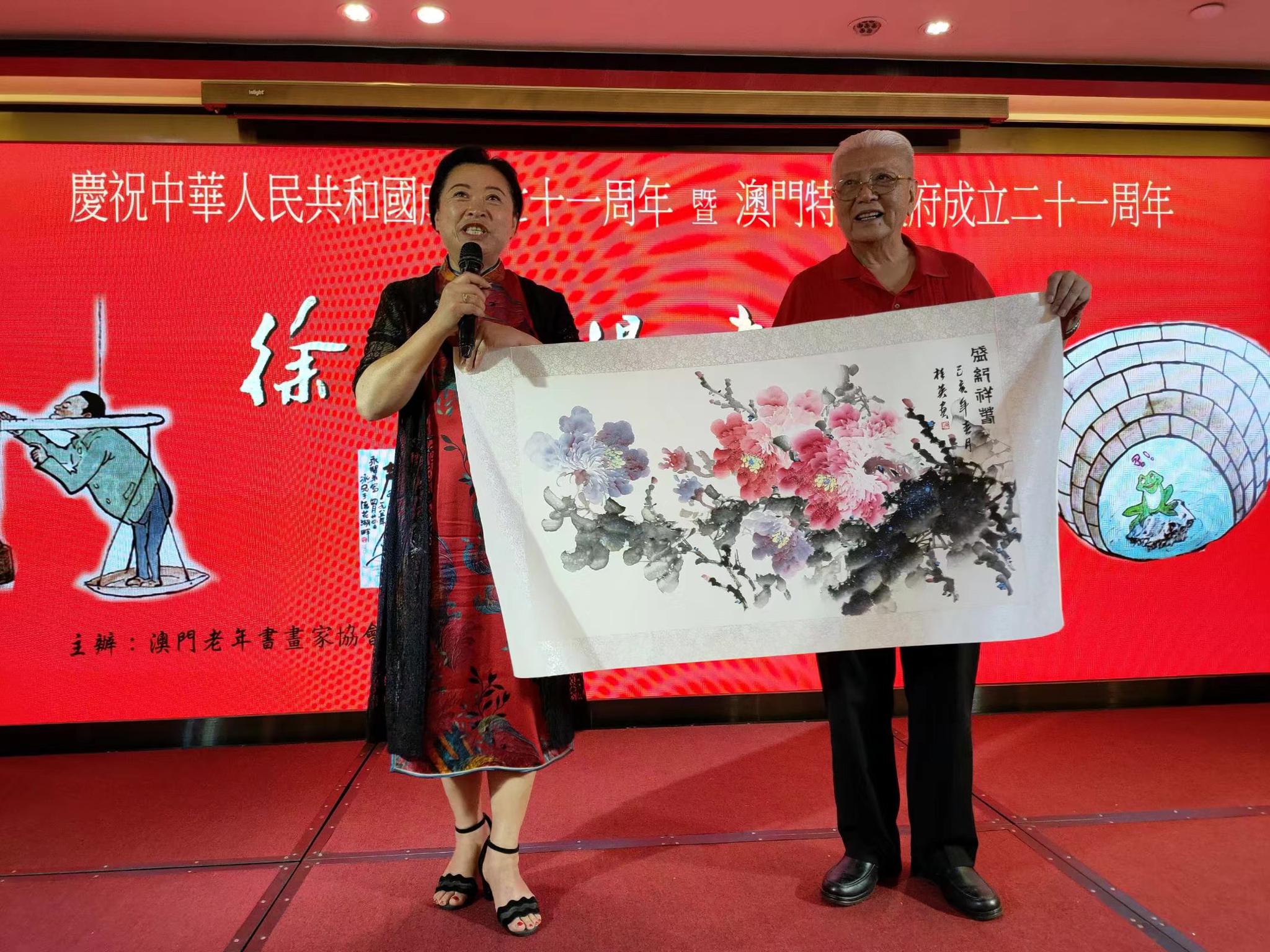 画家陈桂英(左一)作画祝贺徐永智(右一)漫画展成功举办