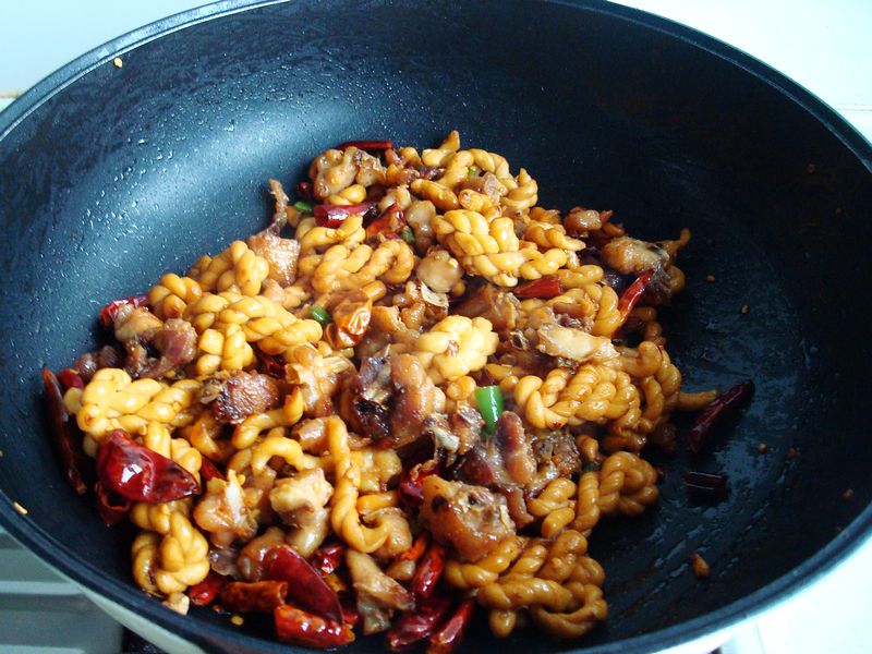 8,撒上青辣椒丁继续翻炒均匀即可出锅7,加小麻花继续翻炒出香辣味,加