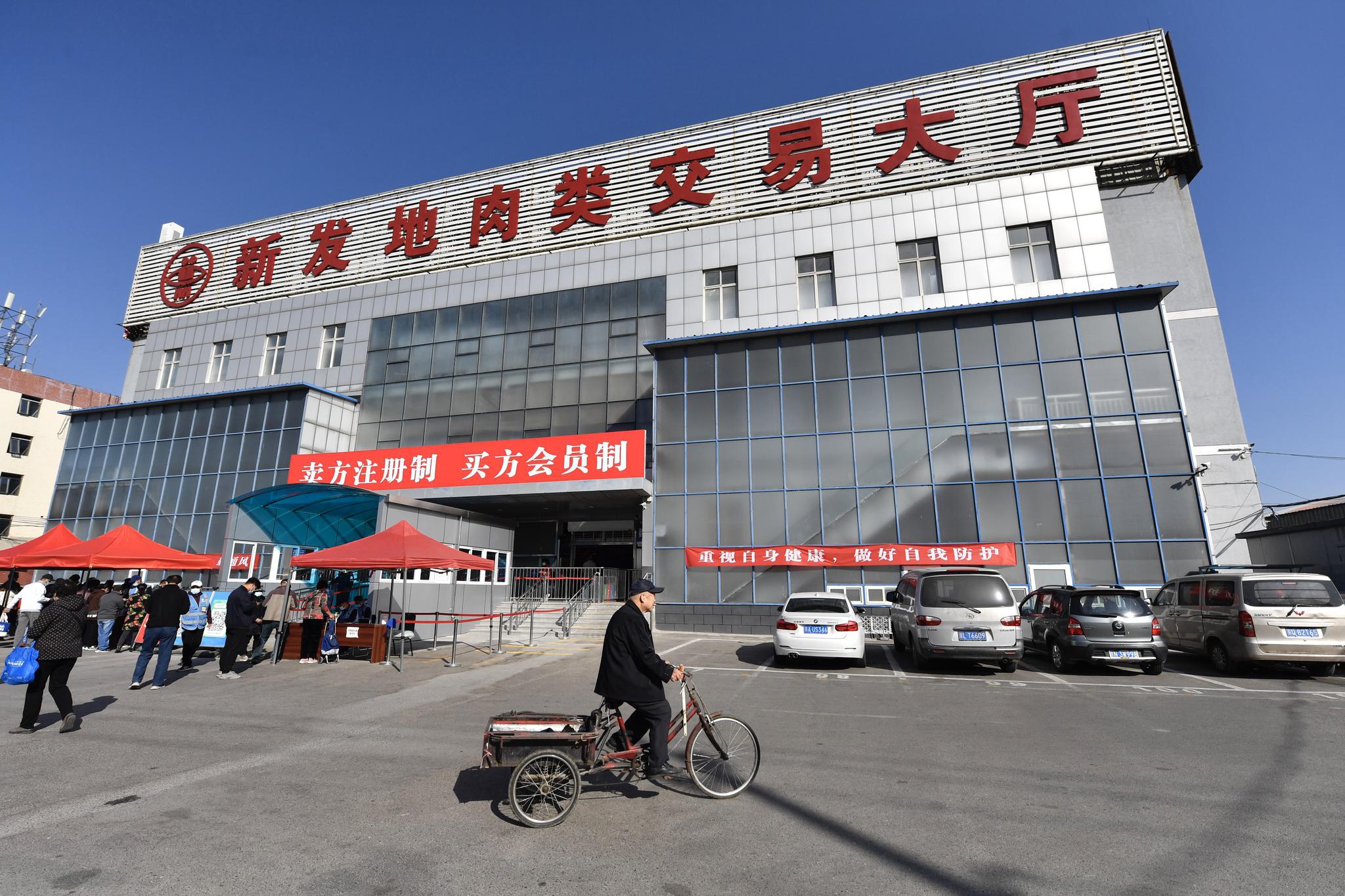 新发地肉类交易大厅前有横幅写着“卖方注册制，买方会员制”。新京报记者 吴宁 摄