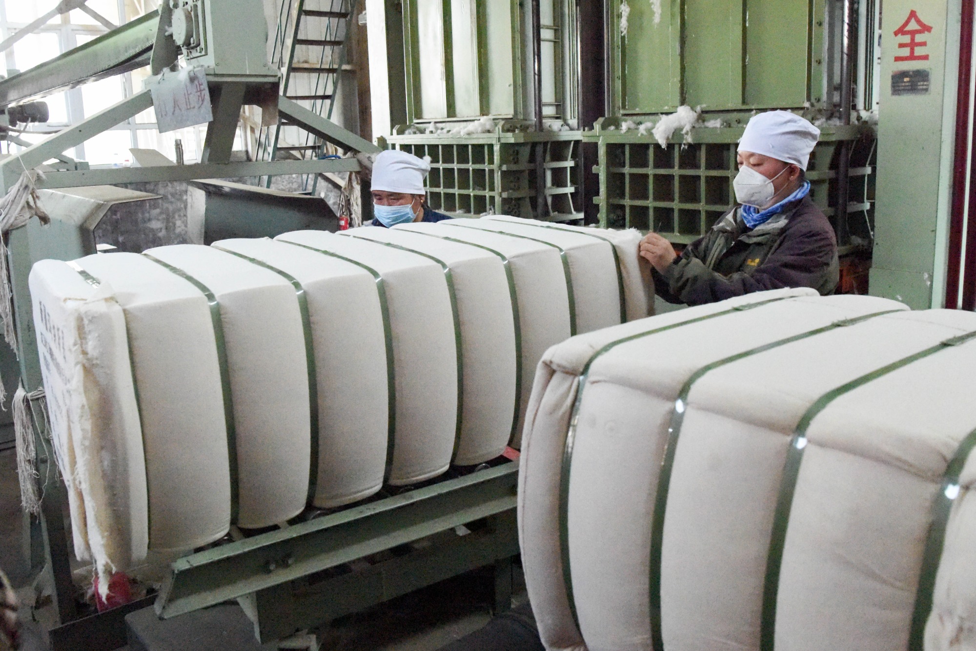 10月17日,在新疆玛纳斯县乐土驿镇轧花厂,工人打包加工好的棉包.