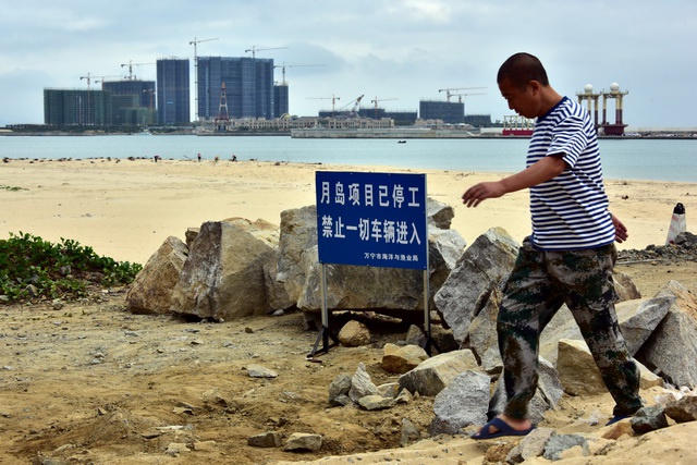 2018年1月20日，进入万宁市日月湾综合旅游度假区人工岛月岛项目的道路被石块封住，并竖起停工标志牌。摄影/章轲