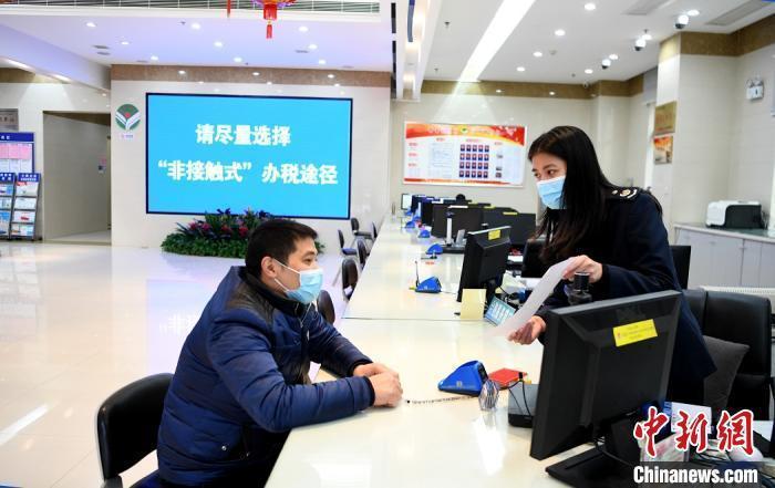 图为基层税务部门在办税厅做好疫情防控宣传。林文 摄