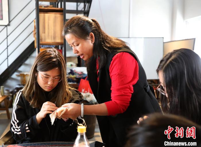 广西苗族刺绣代表性传承人李伊园在指导学生练习刺绣。　韦鼎标 摄