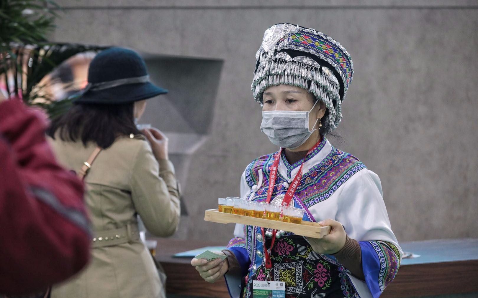 茶展现场，穿着少数民族服装的参会人员正在分发茶水。摄影/新京报记者 王嘉宁