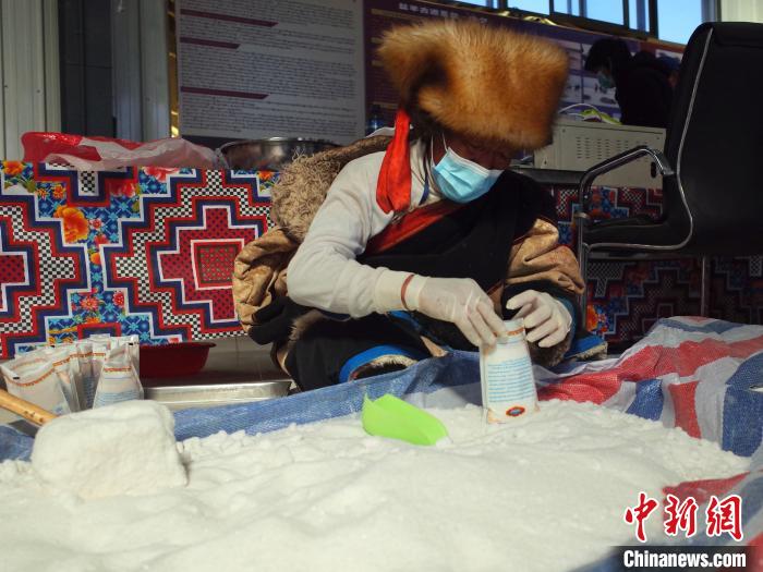 图为正在分装食盐的布玛尔老人 谢牧 摄