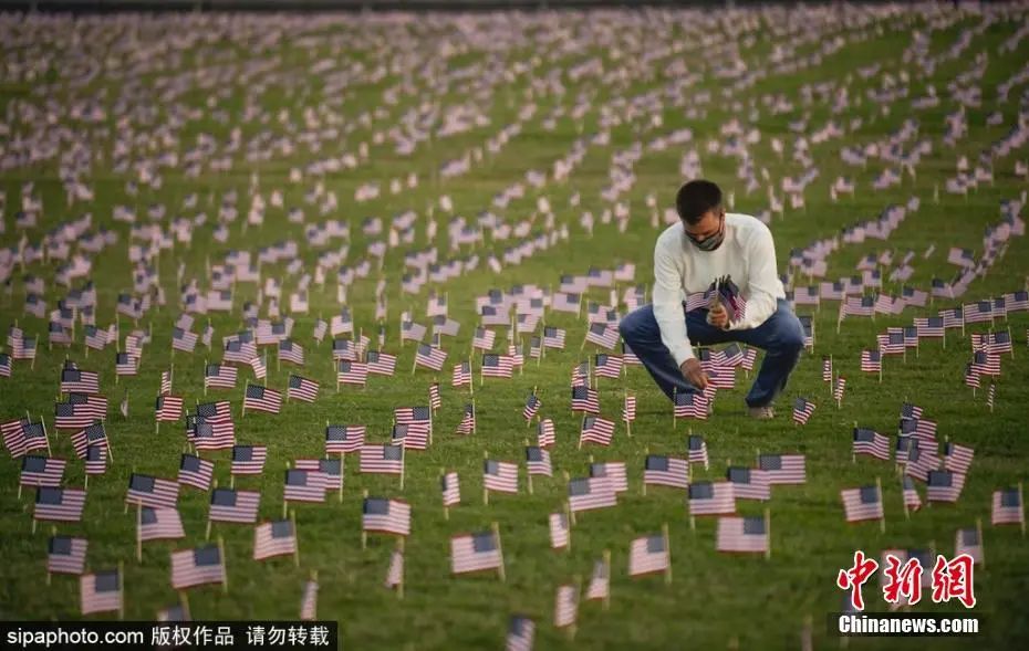 美国华盛顿，志愿者在国家广场上放置2万面美国国旗，纪念新冠肺炎疫情里死亡的人。图片来源：Sipaphoto版权作品 禁止转载