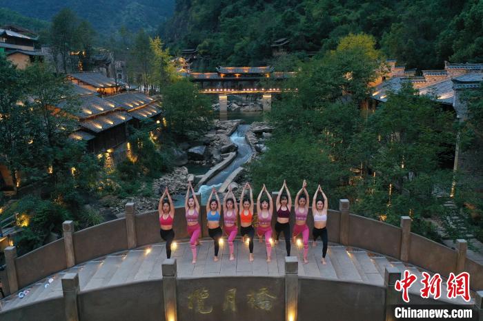 瑜伽爱好者在风景秀美的江西上饶望仙谷一石桥上舒展身姿，练习瑜伽。　刘占昆 摄