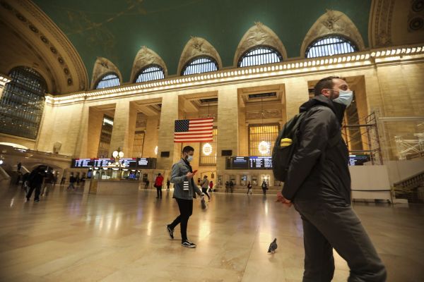 10月16日，人们戴着口罩走过美国纽约中央车站大厅。新华社