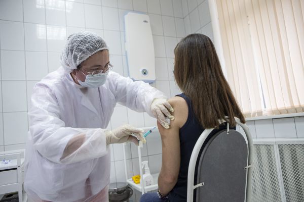 9月15日，在俄罗斯首都莫斯科，医护人员为一名志愿者接种疫苗。新华社发