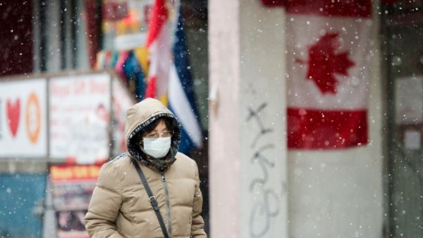 今年2月终,走人戴着口罩冒雪走走在添拿大多伦多商业区。(原料图片)