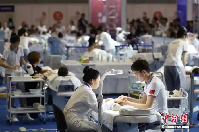 资料图：2018中国技能大赛现场，美容师正在给体验者做指甲。张亨伟 摄