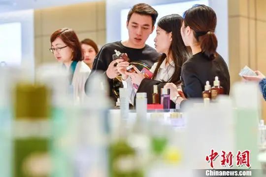 图为民多在海口免税店内选购化妆品。骆云飞 摄