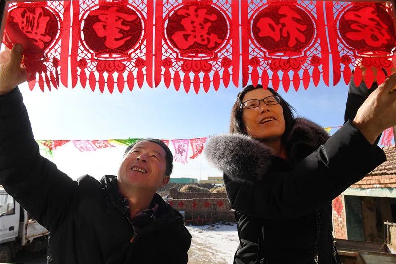 在河北省张北县小二台镇德胜村，村民徐海成（左）和妻子在家中布置春节装饰（2018年2月9日摄）。新华社记者 牟宇 摄