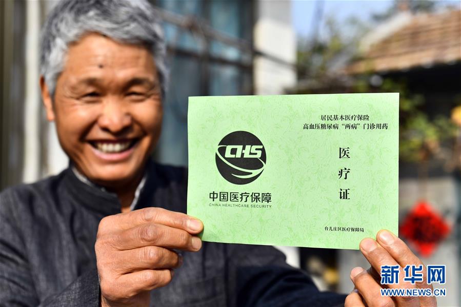 集镇旺庄村,村民王明洋展示自己的高血压糖尿病"两病"门诊用药医疗证