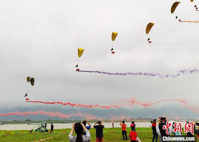 广东肇庆市鼎湖区砚洲岛沙滩乐园上空升起了动力滑翔伞。　曾令华 摄