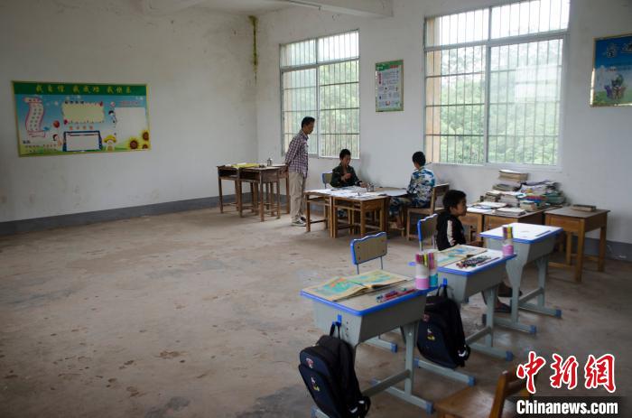 　　梁志雄和阿旺、阿兴、阿山在教室里。翟李强/摄
