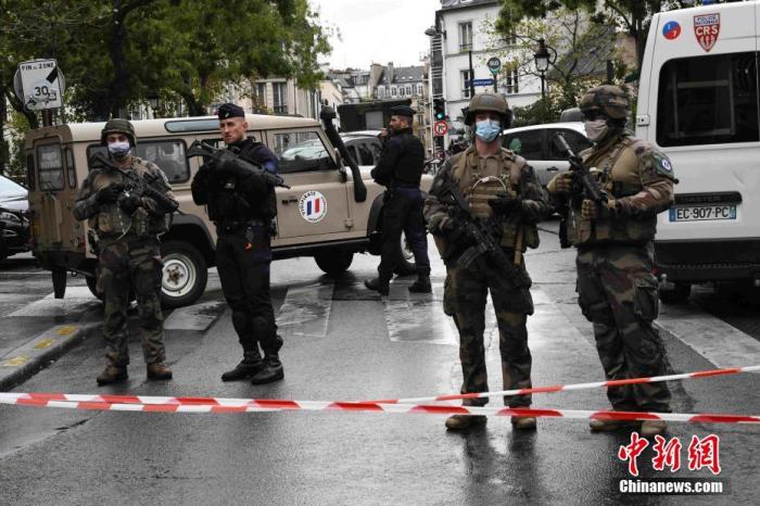 当地时间9月25日，法国首都巴黎发生持刀袭击事件，袭击发生于巴黎十一区的《查理周刊》总部原址附近。图为袭击事件现场戒备森严，法国防暴警察和宪兵持枪巡逻。 中新社记者 李洋 摄