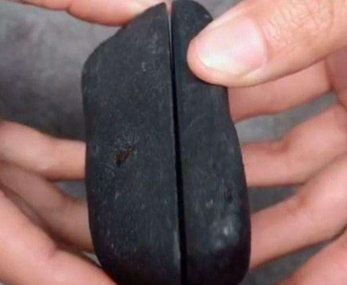 男子捡到块黑碳石,用刀切下后,不料看到里面的东西,情绪失控