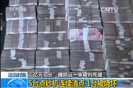 2014年，专案组在魏鹏远一处房屋中搜出大量现金。  央视新闻 截图